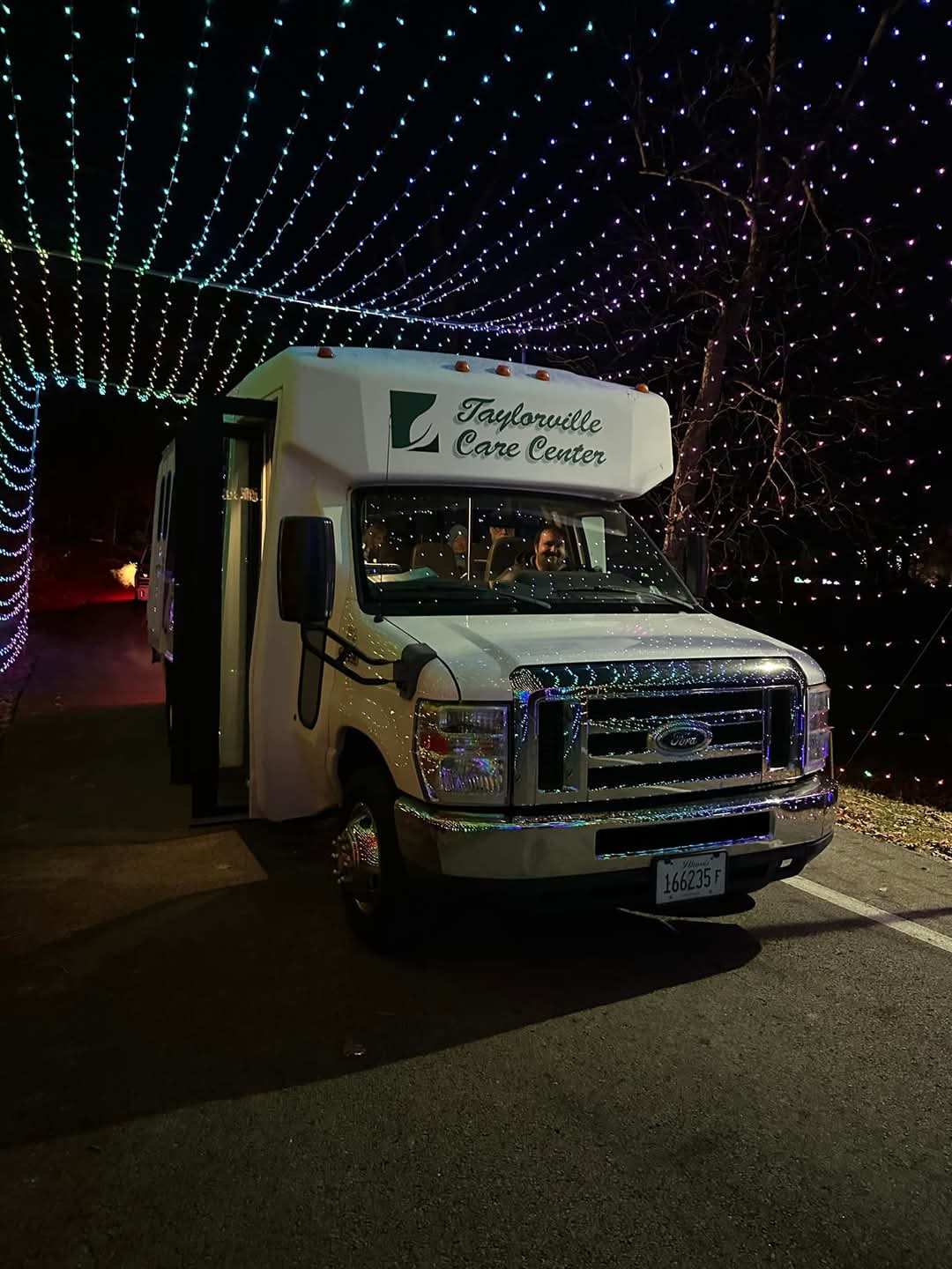shuttle bus under small rows of string lights